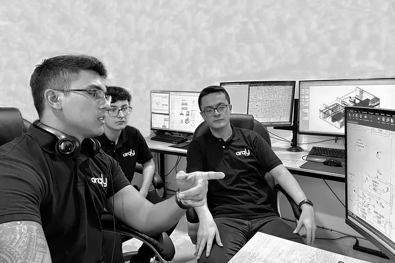 Three Arqly team members discussing a coordinated model at their workstations